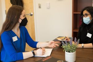 Clinical psychology students discuss a client case in an office on campus.