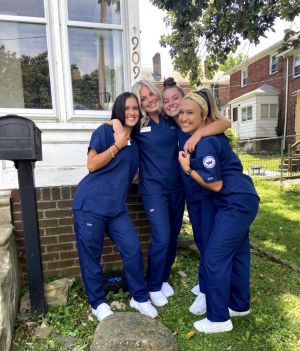 Kelsey Byrd poses in scrubs alongside nursing colleagues.