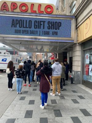 Students walking under the Apollo Theatre marquee
