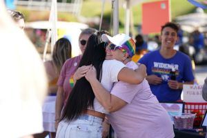 Two individuals embrace at the Homecoming Tailgate Village.