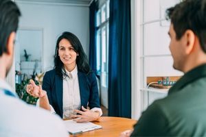 Business meeting 300x200 A woman speaks with two men during a business meeting/
