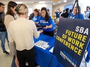 Several People Arrive at the SBA Future of Work Conference Registration Table