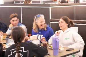 Stacey Robertson eating lunch in the Pride cafe with students.