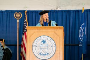 President Stacey Robertson smiles at the podium during commencement.