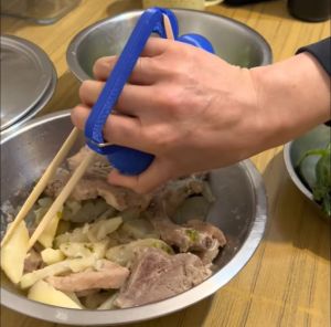 A user practices using chopsticks with the Dexterity Mate.