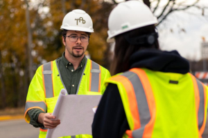 Construction management professional speaks with colleague.
