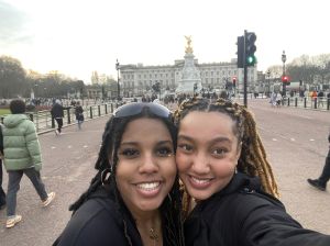 Two students take a selfie in front of Buckingham Palace