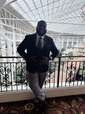 Justin Mack poses for a photo wearing a suit