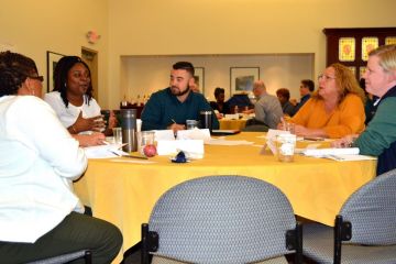 Participants in the Green Dot training talk around a table