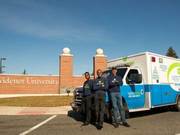 Markevis Gideon and business partners in front of Widener sign