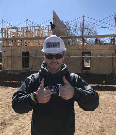 Patrick Wright wearing a hard hat on an Alternative Spring Break worksite 
