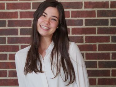 Jenna Muir in front of brick wall