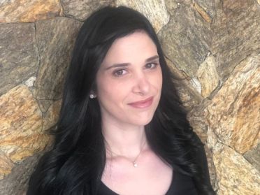 Karina Brasil stands in front of stone wall