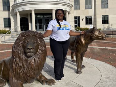 Taylor pictured with the Pride lions statue on campus