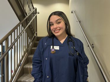 Nursing student Maritza Garcia poses in blue Widener scrubs