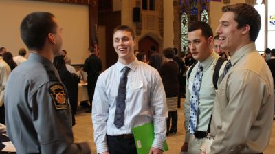 Master's in Criminal Justice Students (MCJ Degree) speak to police officer at career fair while pursuing a criminal justice master's degree