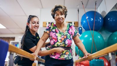 DPT Student with Patient on Walking Bars