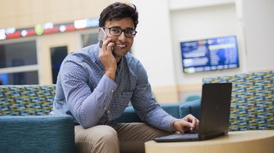 This international business major stays connected on his laptop and phone. 