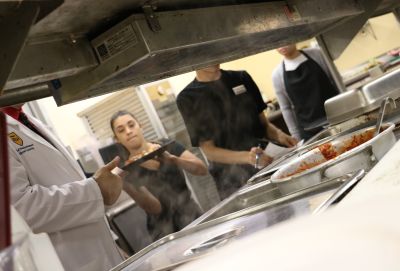 Hospitality and tourism students prepare to serve a meal