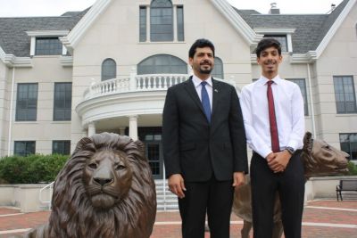 Father and son from Saudi Arabia with lion statue