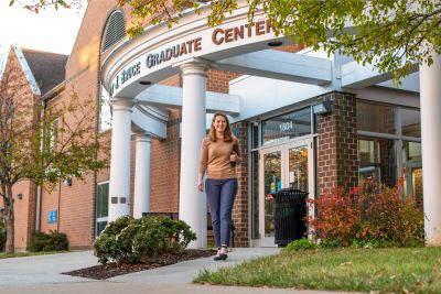 Grad student walking in front of Bruce Hall