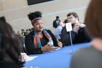 Student converses at table at Common Ground event