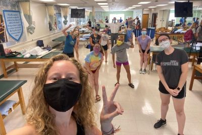 Graduate physical therapy students wear masks and practice social distancing during lab.