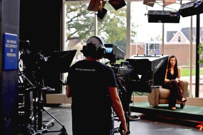 Person filming one of the hosts of the virtual Veterans Parade show in the TV studio