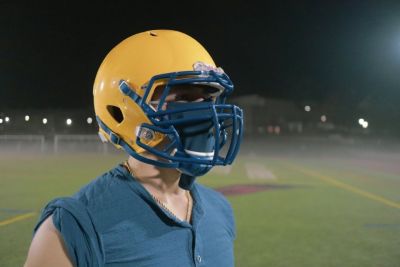 A football players wears the achieve mask under his helmet