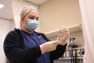 Nursing student prepares an immunization in a clinical setting.