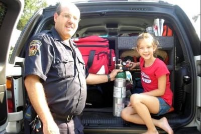A photo from the past shows Gary and Stephanie posing together next to Gary's paramedic vehicle.
