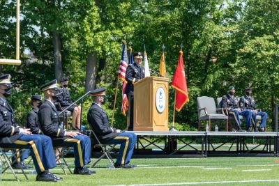 Cadets and ROTC officers seated on the Widener football field for commissioning ceremony