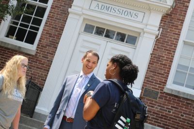 Vice President for Enrollment Joseph Howard talks with two students in front of Muller Hall