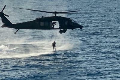 Widener R-O-T-C cadet hangs from a rope from a helicopter above water