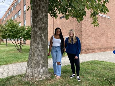 Two students stand outside of Kirkbride Hall