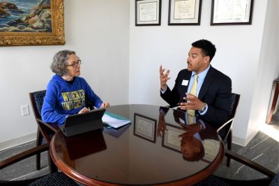 President Wollman seated next two student Willie Mathis in conversation