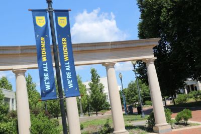 Two banners on campus read "We're All Widener"