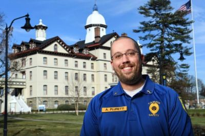 Anthony Pluretti poses in uniform in front of the historic Old Main building.