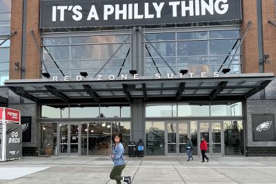 Student Donya Moore in front of Lincoln Financial Field and a sign that says It's a Philly Thing