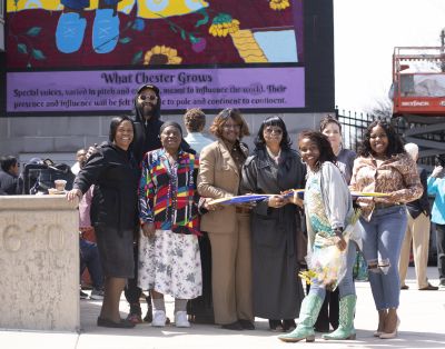 Eight people involved in the creation of the mural pose in front of it