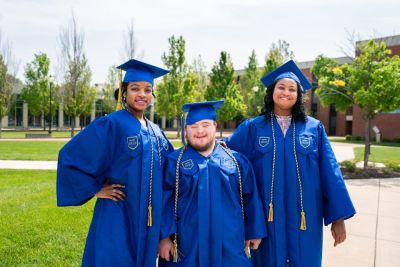 Students pose in blue regalia at commencement.