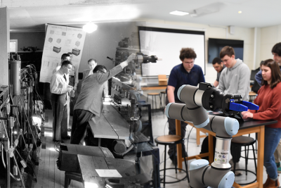 A historic black and white photo of men in a classroom blends into a modern color photo of students in a classroom