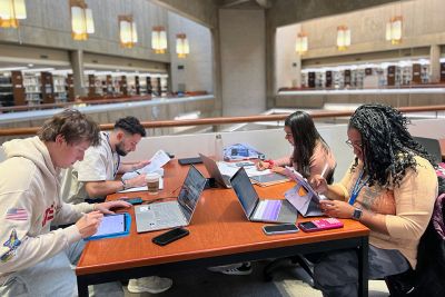 Four students studying at a table in the library