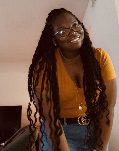 Kennedy Shaw poses for a photo while wearing a yellow shirt.