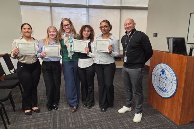 Four SBA students, a faculty member and a CO-OP supervisor standing together, posed during Honors Week