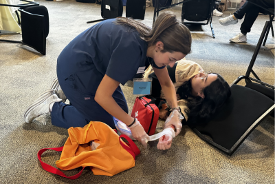 Two nursing students take part in a simulated disaster event. One is acting as a "victim" and one as a "first responder"