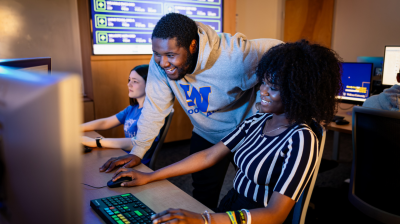 Students in Widener University's School of Business look at a computer in the on-campus finance lab.