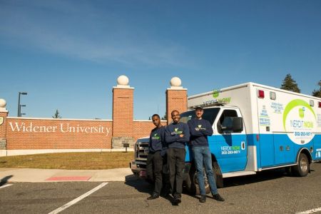 Alumnus Markevis Gideon and his business partners with a mobile repair van and Widener sign