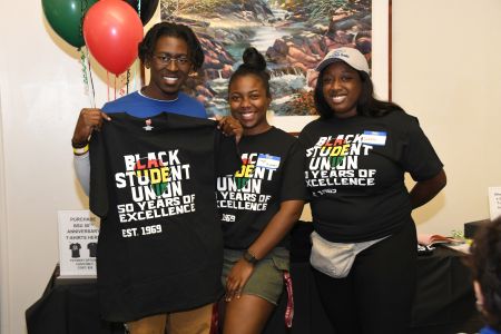 Black Student Union 50th anniversary celebration with 3 students wearing or holding commemorative T-shirts