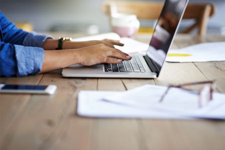 Person typing on computer from home